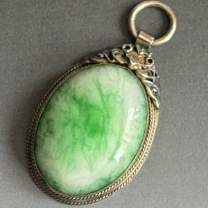 Cabochón de jade fino con montadura de alpaca labrada y filigrana.